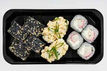 Close-up of sushi rolls made of sausage and covered with cabbage and ketchup. Homemade asian style. Sushi-food hybrids trend. Japanese food.