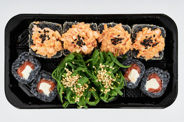 Close-up of sushi rolls made of sausage and covered with cabbage and ketchup. Homemade asian style. Sushi-food hybrids trend. Japanese food.