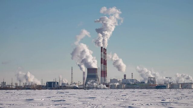 Termal power plant. Combined cycle gas turbine power plant. Large steaming hyperboloid cooling tower and smoking chimneys. Timelapse video