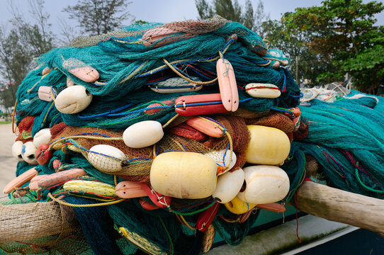 Fishing equipment, nets, and floats are dried on the shore.