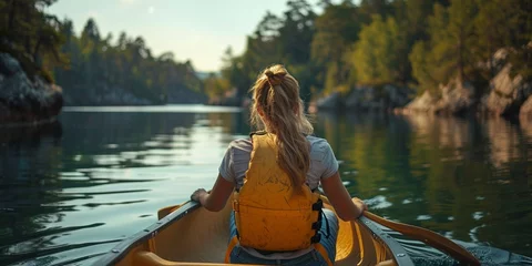 Foto op Canvas A woman rows a canoe on a serene lake, surrounded by nature, capturing the essence of adventurous relaxation. © Iryna