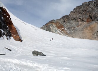 Fototapeta na wymiar hikers, trekkers, mountaineers, white snow plain glacier