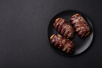 Delicious sweet chocolate cakes with fruit filling and sprinkles on a ceramic plate