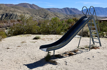 old fashioned metal slide in a desert playground