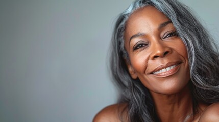Naklejka premium An older woman with grey hair is smiling warmly in a candid portrait