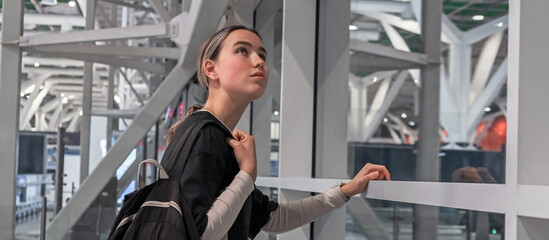 Fototapeta na wymiar Travel, airport, woman waiting for a flight looking out the window, solo travel, airport transit area, travel experiences, authentic travel