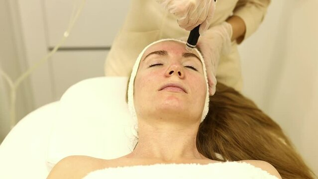 Face cleansing. Face of a nice goo looking woman during hydrafacial procedure in the beauty salon.