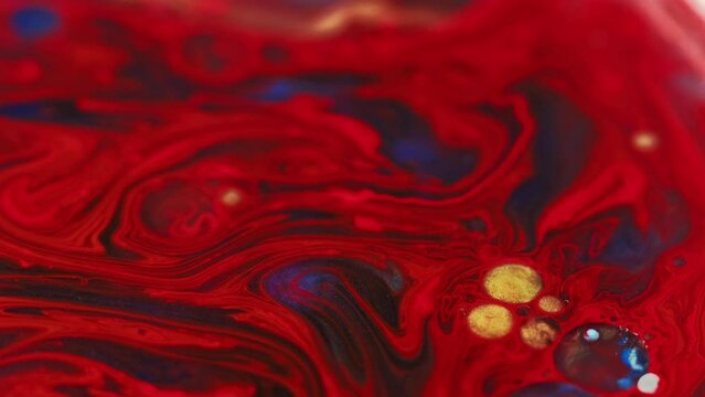 Paint blend. Oil bubbles. Occult mist. Defocused red gold blue color glitter ink round droplets floating mix motion abstract art background.