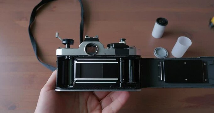 Point of View of Man Hand Putting a Roll of Film Into a Film Camera. Changing Film to Vintage Old Camera. Photography Concept