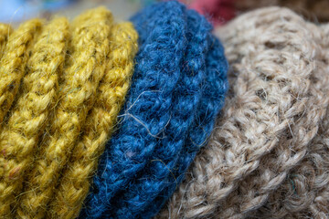 Jute products in blue yellow and natural wood colors are crocheted for a coaster or washcloth.