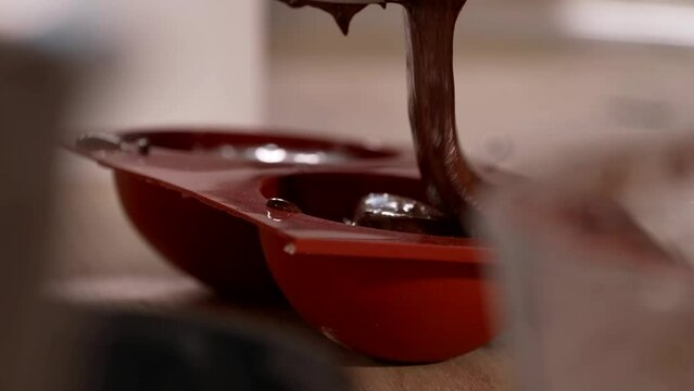the pastry chef pours the chocolate into the mold
