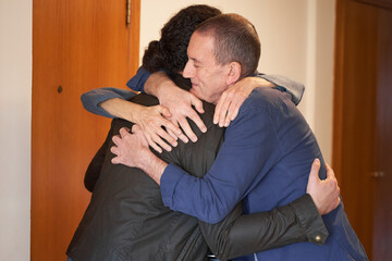 Obraz premium Son hugging senior parents with love
