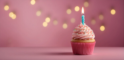 Un petit cup cake en forme de gâteau d'anniversaire avec de la crème et une bougie allumée sur un fond rose dans une ambiance festive - obrazy, fototapety, plakaty