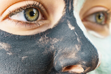Girl black and green mud mask on face