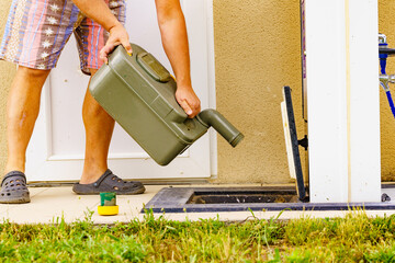 Man emptying caravan tank toilet cassette in dump station.