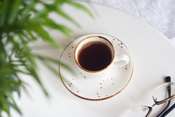 Black coffee in a mug on a white round table