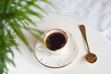 Black coffee in a mug on a white round table