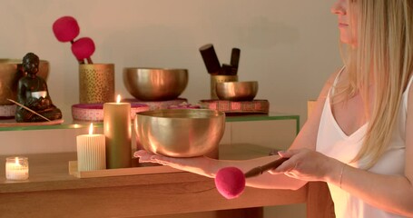 Using Singing Bowls for Relaxation. Woman is immersed in the calming sounds and vibrations produced by the singing bowls, facilitating a state of deep relaxation and stress relief.
