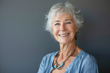 Lovely Seventy Year Old Woman Smiling in Blue Shirt with Copyspace.