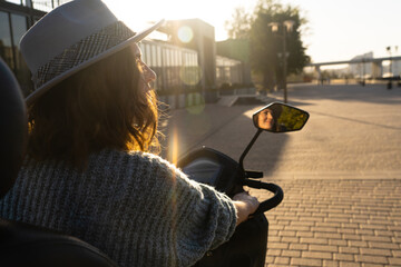 Woman tourist on a four wheel mobility electric scooter on a city street. The woman's face is...
