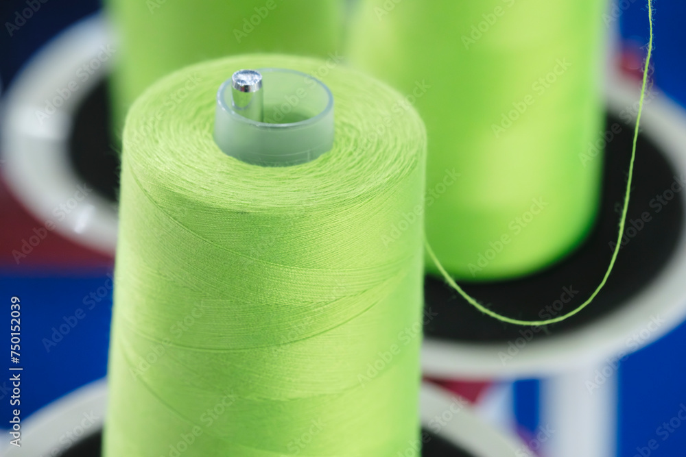 Aufkleber spools of color threads closeup, spinning machine