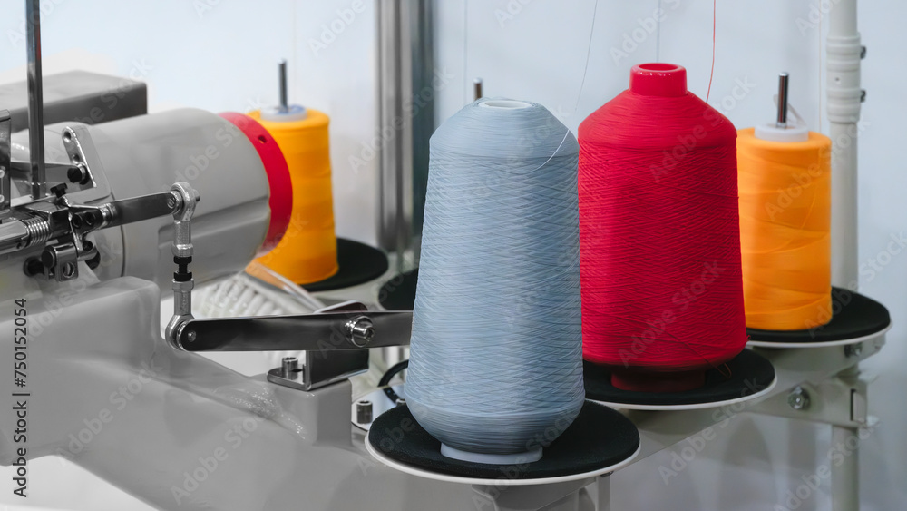 Aufkleber spools of color threads closeup, spinning machine