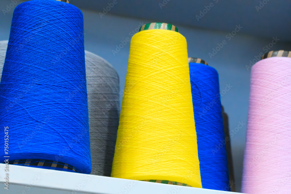 Poster spools of color threads closeup for spinning machine