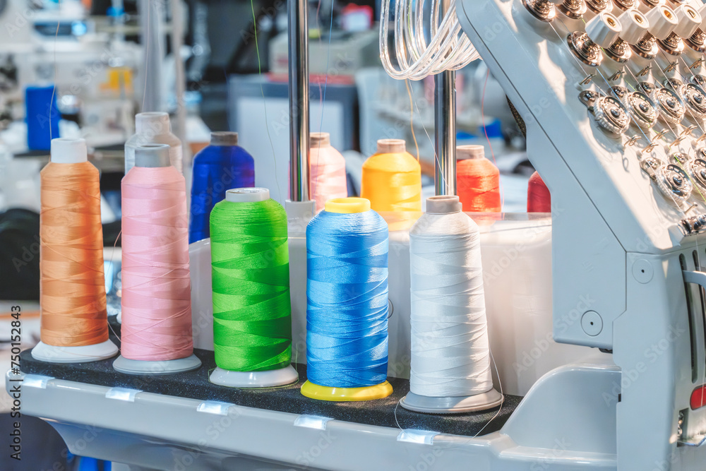 Aufkleber spools of color threads closeup, spinning machine
