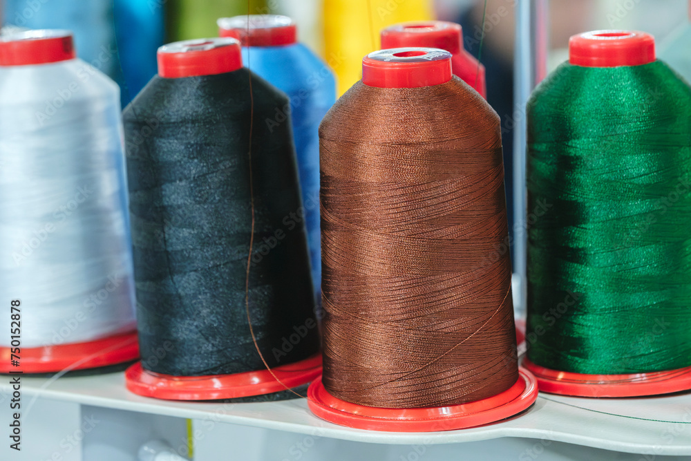 Aufkleber spools of color threads closeup, spinning machine