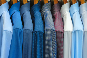 Multi-colored men's shirts on hangers in a store or store - 750153051