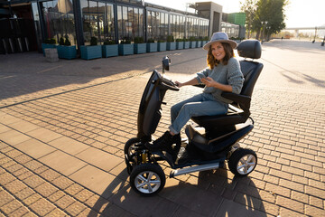 Woman tourist riding a four wheel mobility electric scooter on a city street
