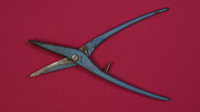 Vintage blue metal pliers. Tools in action on color background. Loopable stop motion animation. 4K top view. DIY video concept.
