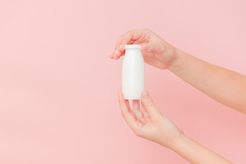 Hand holding bottle of probiotic yogurt for digestive system. Dietary supplements for stomach