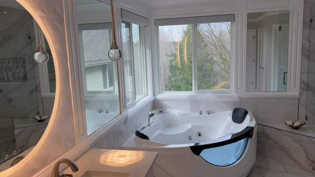 Spacious modern contemporary master bathroom with jacuzzi hot tube and large glass walk in shower including towel warmer rack