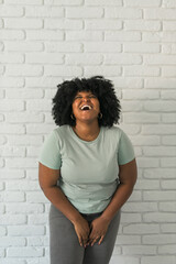 Laughing African American woman with an afro hairstyle and good sense of humor smiling and laugh on...