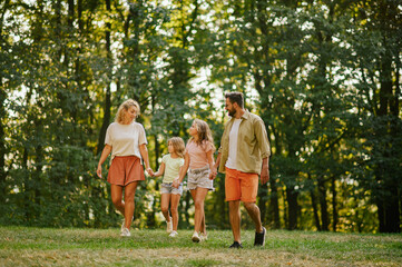Fototapeta premium A loving family spending time together in forest and taking a walk.