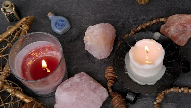 esoteric table, female fortuneteller's hand holding and using rose quartz stone, candles burn, healing session, ambiance of mystical rituals, immersive experience, divination practices