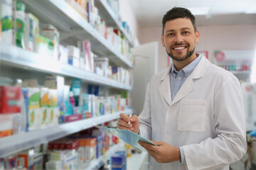 Professional pharmacist near shelves with merchandise in modern drugstore