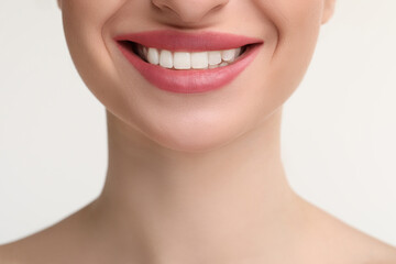 Young woman with beautiful smile on white background, closeup