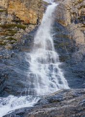 small waterfall falling from a cliff in the mountains - 750169885