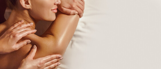 Woman enjoying shoulder massage in spa salon