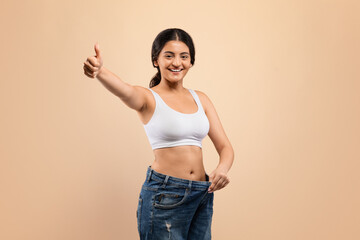 Weight Loss Result. Indian Woman Wearing Oversized Jeans And Showing Thumb Up