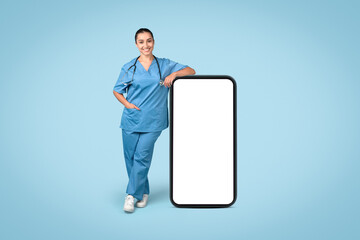 Woman nurse with big smartphone mockup on blue, medical ad