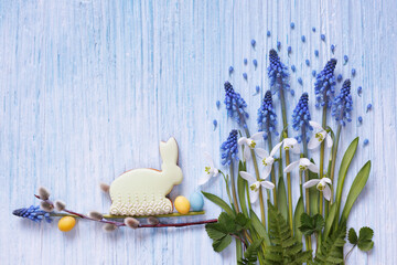Decorative spring background with muscari flowers, snowdrops, leaves, cookie bunny and candy eggs. Easter card, copy space - 750184845
