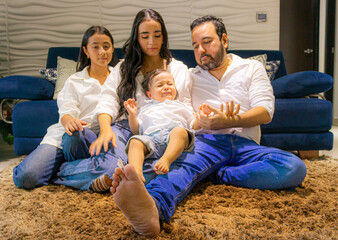 Latin Colombian family sitting on a rug while the child is crying