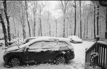 looking through the window at the cars covered with snow after the snow storm late winter in black and white