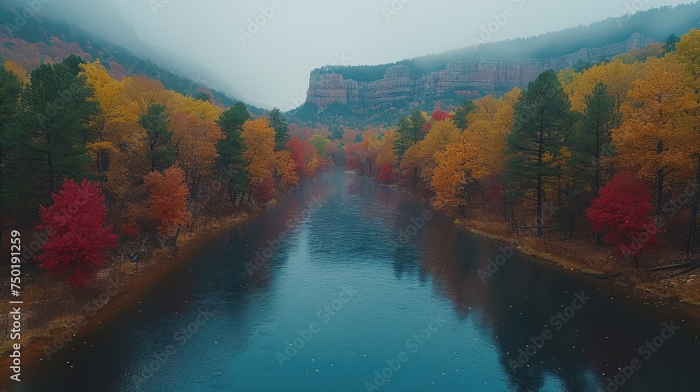 Poster a body of water surrounded by trees with yellow and red leaves on the trees in the foreground and a 