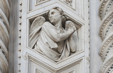 Fototapeta premium Angel in white marble, detail on the front gable from the Cattedrale di Santa Maria del Fiore (cathedral of Saint Mary) in Florence, Italy