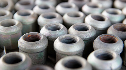 Close-up of bright and shiny nuts for fastening an element of a car, tractor, truck, heavy equipment. industrial background