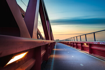 Red railroad bridge named 'Hanzeboog' over the IJssel river in the dutch Delta landscape - 750193418
